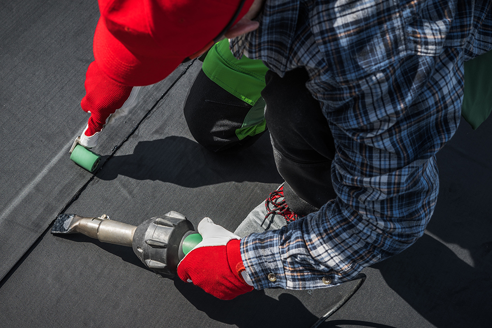 Close up of a Allsite Roofing LLC worker installing new EPDM roof