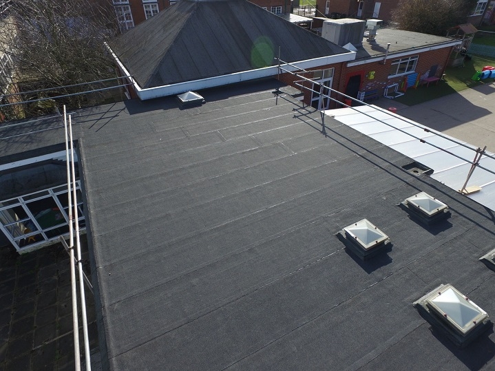 Close up of a Allsite Roofing LLC worker installing new Modified Bitumen Metal roof