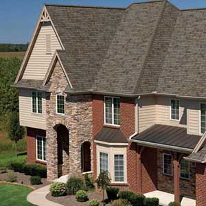 Front view of a higher-end two-story home with light gray Owens Corning shingles on its roof